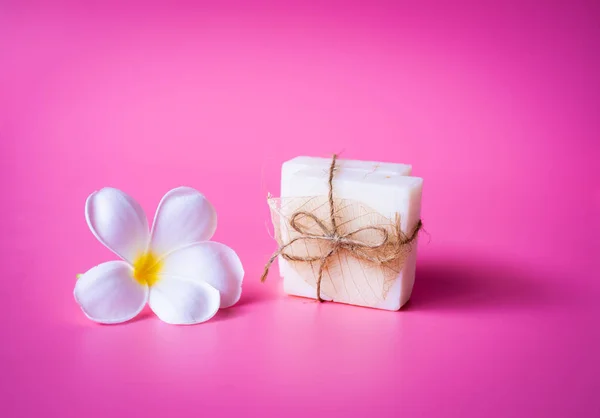 Hermosa flor de Plumeria blanca y jabón de leche sobre fondo rosa — Foto de Stock