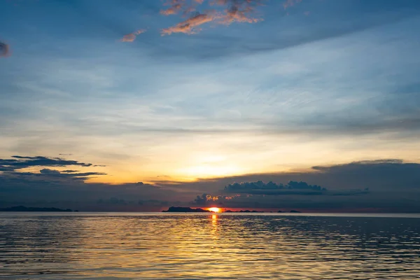 Mavi deniz ve altın ışık gökyüzü bulutu ile güzel plaj gün batımı — Stok fotoğraf
