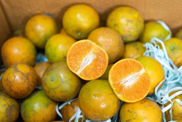แพ็คผลไม้สีส้มในพื้นหลังกล่องกระดาษ — ภาพถ่ายสต็อก
