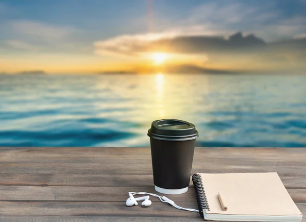 커피 컵, 귀 전화 및 노트북 이온 나무 상단 바다 풍경 — 스톡 사진