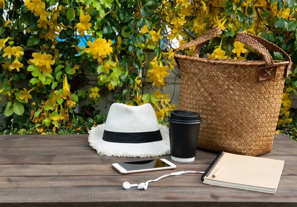 咖啡杯，笔记本，电话，巴拿马帽子和藤袋在木塔 — 图库照片