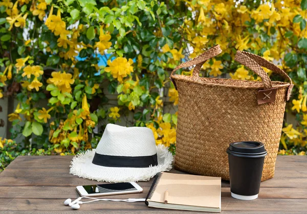 咖啡杯，笔记本，电话，巴拿马帽子和藤袋在木塔 — 图库照片