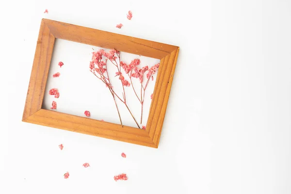 Hermosas flores secas rosadas decoradas con marco de madera marrón i — Foto de Stock