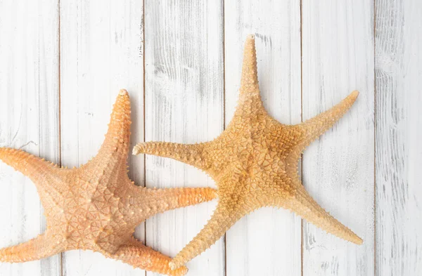 Big starfishs no fundo superior da mesa de madeira branca, vista superior — Fotografia de Stock