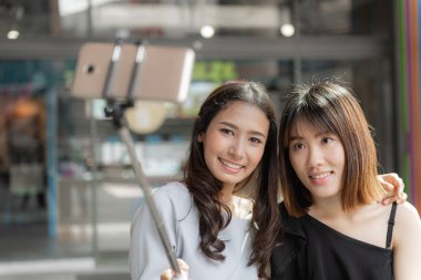 Selfie çeken iki gülümseyen neşeli kız arkadaş portresi 