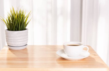 Morni ile ahşap ofis masası üzerinde beyaz kahve fincanı ve bitki demliği