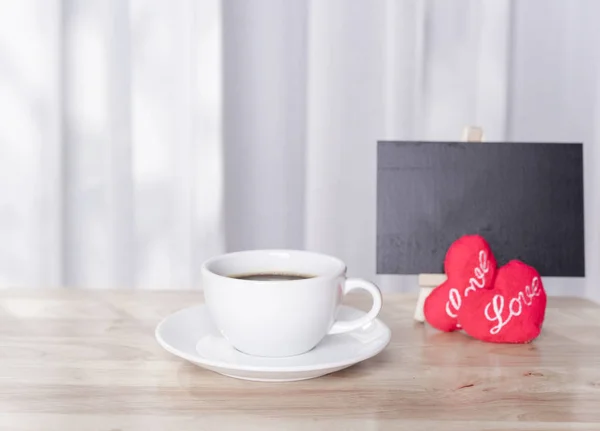 Hot coffee cup with red hearts shape symbol  and black board on — Stock Photo, Image