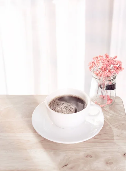 Bílý šálek kávy s kouřem, červená sušená květina na dřevěné kanceláři d — Stock fotografie