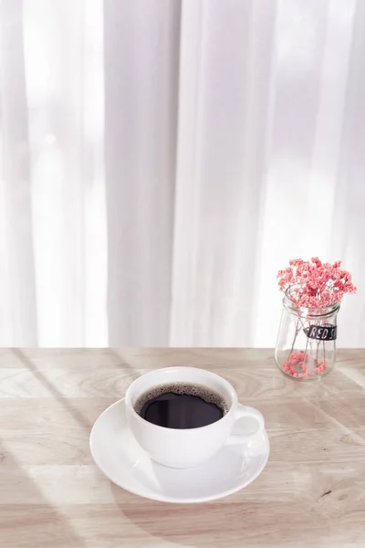 Taza de café blanco, flor roja seca en escritorio de oficina de madera con m — Foto de Stock