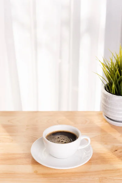 Vit kaffekopp och kruka på trä kontorsbord med morni — Stockfoto