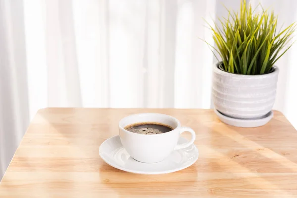 Vit kaffekopp och kruka på trä kontorsbord med morni — Stockfoto