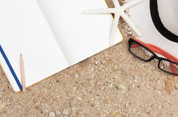 Vacaciones de verano en la playa con cuaderno, gafas de sol, sombrero de panama, starfis —  Fotos de Stock