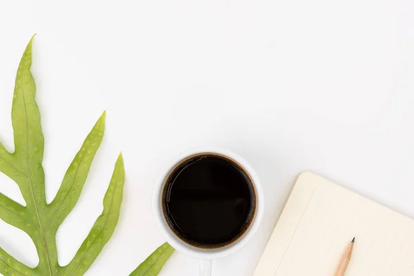 Escritorio de oficina con café negro, cuaderno, lápiz y gre — Foto de Stock