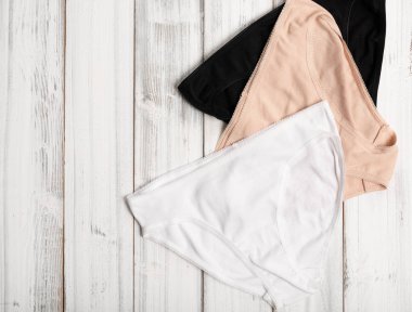 Beyaz ahşap arka plan üzerine kurulmuş kadın külot, üst görünümü