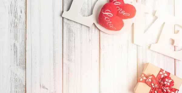 Milostný text, Dárkový box a symbol srdce na bílém dřevěném pozadí — Stock fotografie