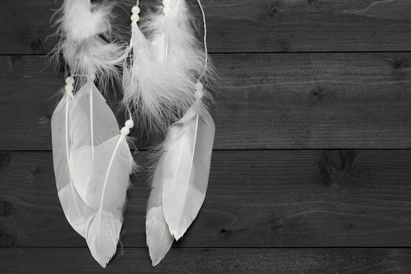 Black and white dream catcher on wooden background, flat lay — стоковое фото