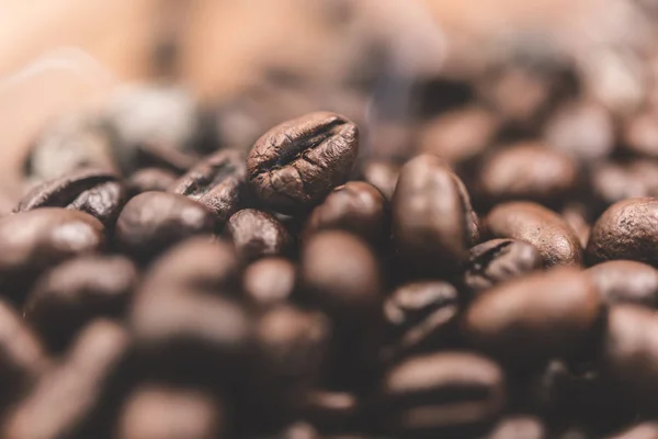 Aroma granos de café tostados con humo subiendo sobre fondo oscuro —  Fotos de Stock