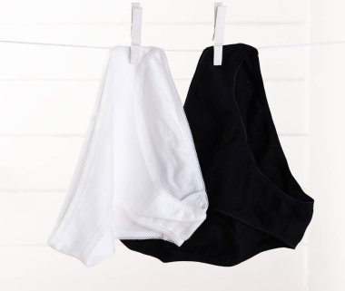 Beyaz ve siyah iç çamaşırlı kadın ahşap sırtüstü ip üzerinde kurumuş.