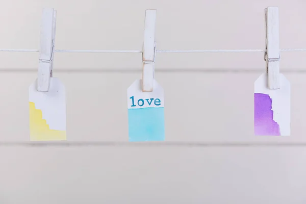 Étiquette Love pendre avec corde et épingle à linge sur fond de bois blanc — Photo