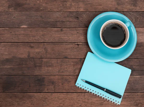 Tazza di caffè blu, penna e taccuino sul tavolo in legno grunge indietro — Foto Stock