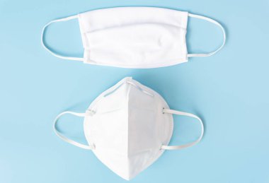 Korona virüsünden korumak için mikrop koruması takmak için cerrahi beyaz maske. Mavi ve beyaz tonda ayarlanmış, üst görünüm