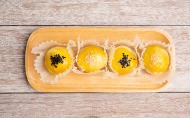 Ahşap tepside siyah beyaz susam tohumlu Çin pastanesi, üst manzara.