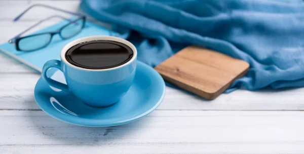 Blue coffee cup   on white wooden  desk background