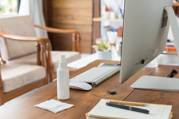 Work from home office gadget hygiene with computer and hand sanitizer protection from coronavirus outbreak or Covid-19  in living room