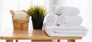 Banyo ve spa seti vücut bakımı ve banyo aksesuarları için ev yapımı kozmetik ürünleri. İçinde sabun, fırça, mum, yağ, tarak ve beyaz havlular var.