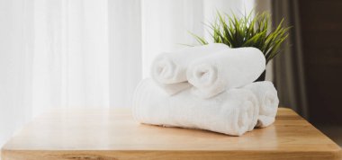  Beyaz yumuşak havlular ahşap masanın üzerine katlanmış ve arka planı bulanık.