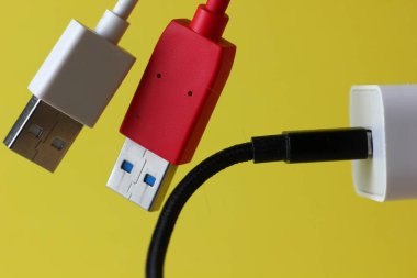 sarı arkaplandaki renkli usb şarj kabloları