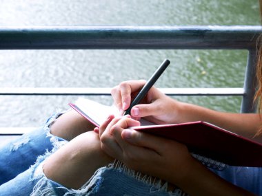 Kitap genel parkta güzel kız teen oturma ve okuma.