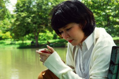 Seyir ve cep telefonu parkta oynarken güzel kadınlar.