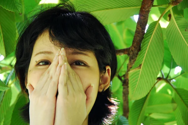 Porträt Eines Schüchternen Asiatischen Mädchens Das Gesicht Mit Händen Versteckt lizenzfreie Stockfotos