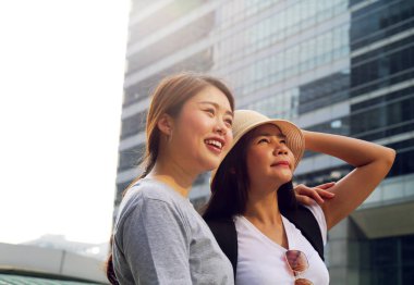 Güzel iki genç kadın yakından gülümseme portre ve şehrin çevresinde yürüyüş seyahat.