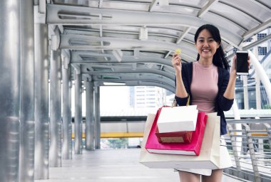 Bitcoin ve hareket eden telefon aygıt tutan güzel kadın.