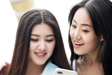 Hareket eden telefon aygıt ve ofis binası arka plan oynamaya yakın çekim güzel iki kadın.