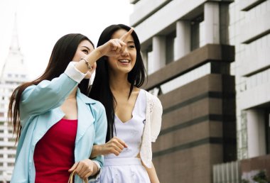Yakın plan güzel iki genç kadın şehri geziyor.