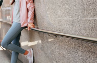 Duvara duran genç kadın düşük bölüm görünümü