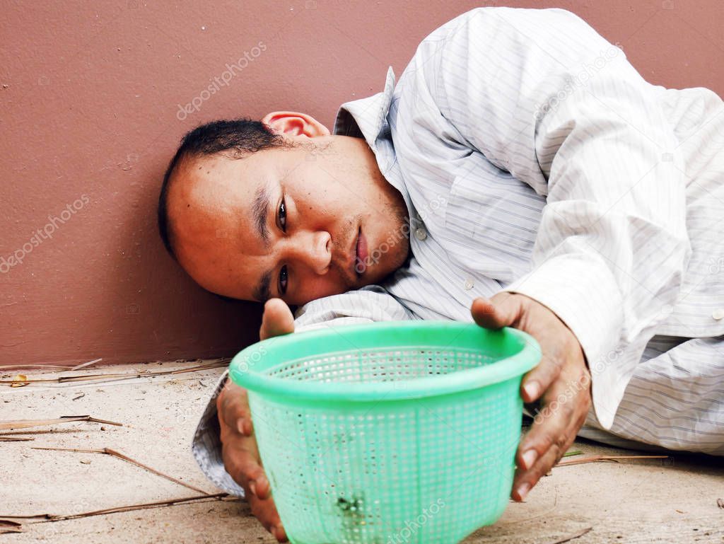 Homeless man sleeping and sadness on walking street.