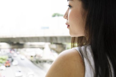 Yakın çekim güzel kadın mutlu gülümseme ve şehirde arıyor.