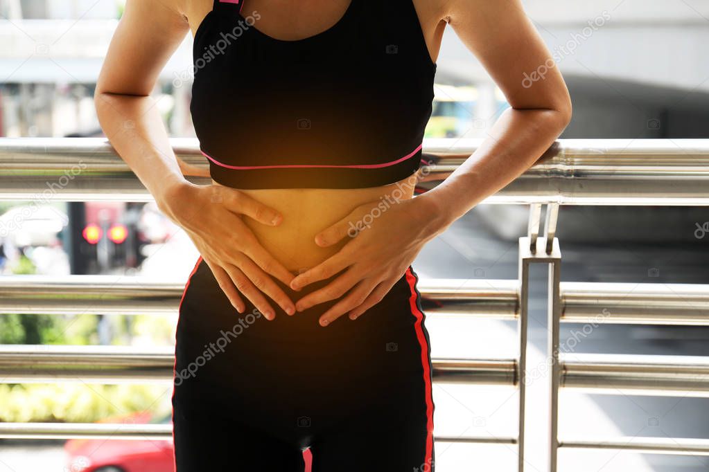 Female athletes, abdominal pain, menstrual period during exercise on walking street in the city.