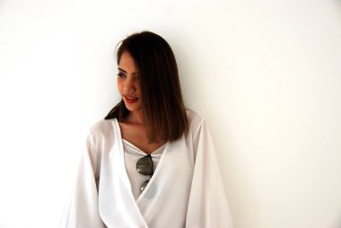 Güzel Asya kız gülümseyen portre ve beyaz renk bina arka plan.