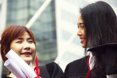 Güzel iki Asya kız öğrenciler mezuniyetten sonra mutluyuz.