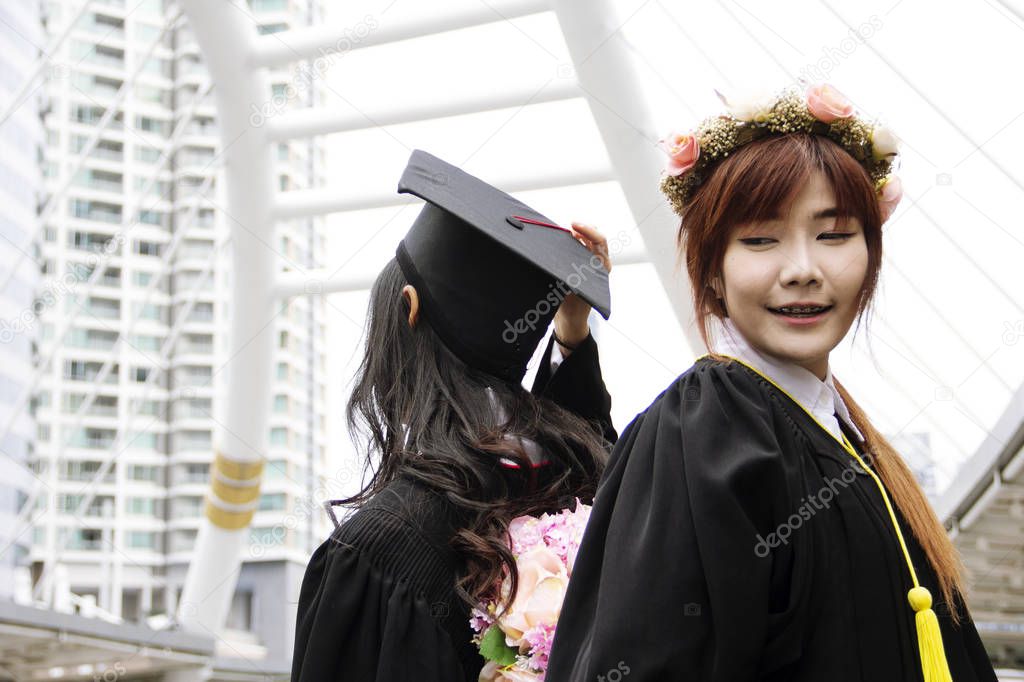 Beautiful Graduate graduates two asia woman smile and are happy after graduation.