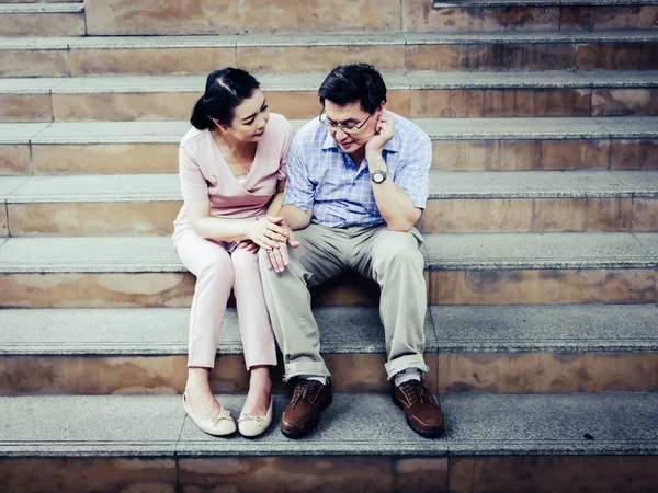 Senior couple sadness and worry healthy on walking street.