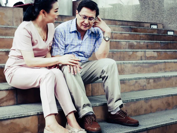 Senior couple sadness and worry healthy on walking street.