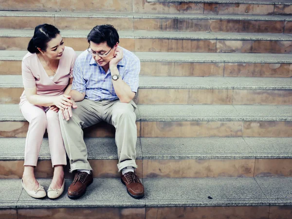 Senior couple sadness and worry healthy on walking street.