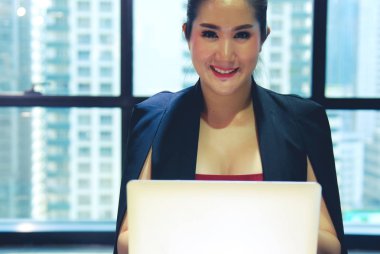 Güzel kadın çalışan oturan ve ofiste masada pc görünümlü.