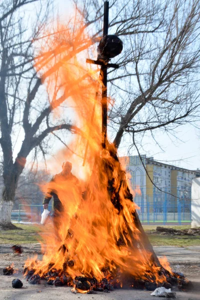 Slavic holiday end of winter. A large terry doll of straw is burning. Black smoke is visible
